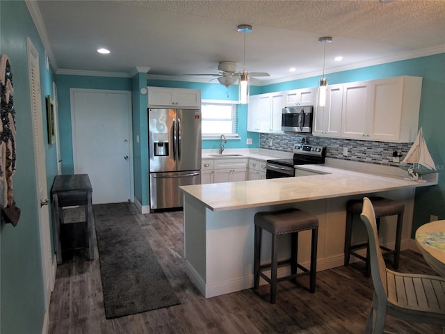 kitchen featuring white cabinetry, dark wood-type flooring, ceiling fan, stainless steel appliances, and kitchen peninsula