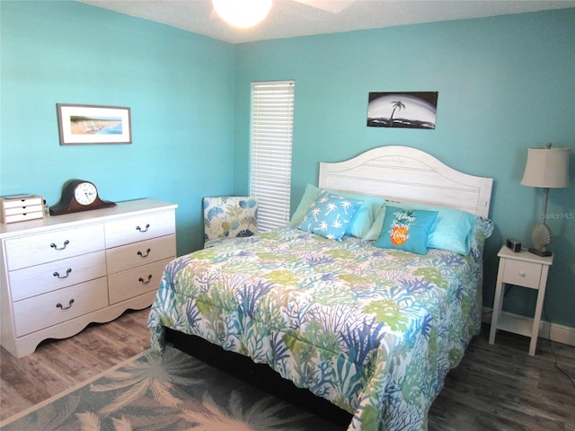 bedroom with ceiling fan and dark wood-type flooring