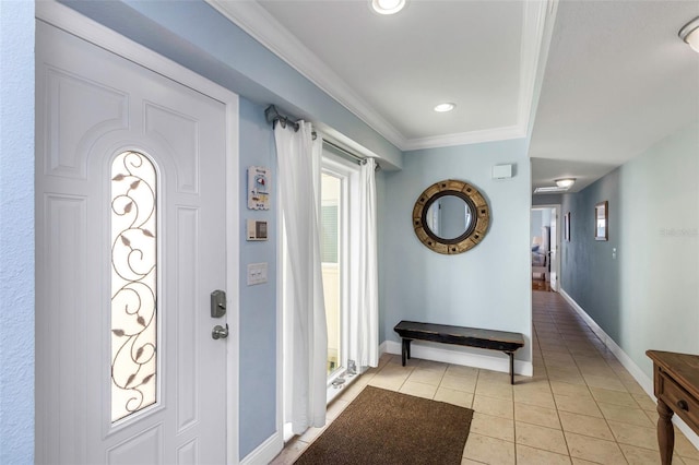 foyer with light tile patterned floors and crown molding