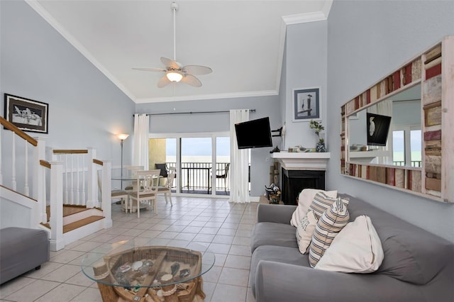 tiled living room with ceiling fan, ornamental molding, and high vaulted ceiling