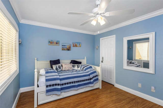 bedroom with hardwood / wood-style flooring, ceiling fan, and ornamental molding