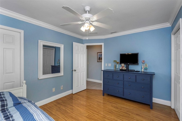 bedroom featuring ceiling fan, light hardwood / wood-style floors, and ornamental molding