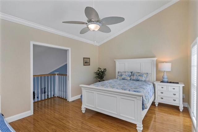 bedroom with ceiling fan, lofted ceiling, ornamental molding, and light hardwood / wood-style flooring