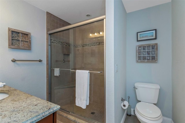 bathroom with tile patterned flooring, vanity, toilet, and a shower with door