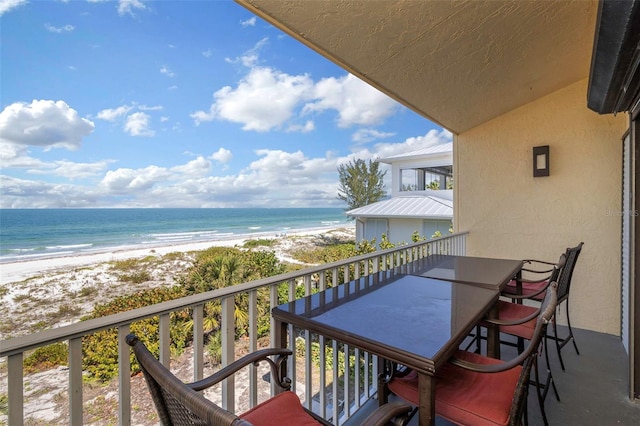 balcony featuring a water view and a beach view