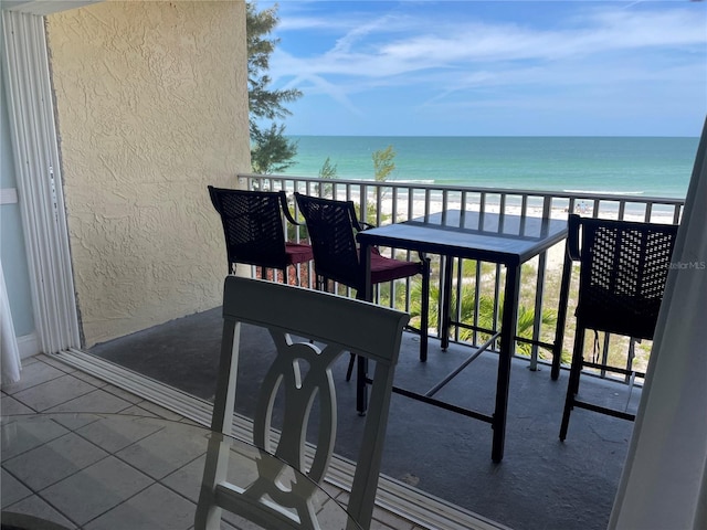 balcony featuring a water view and a beach view