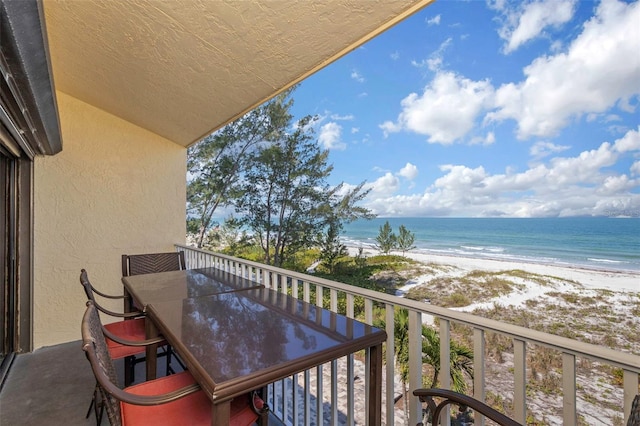 balcony featuring a view of the beach and a water view