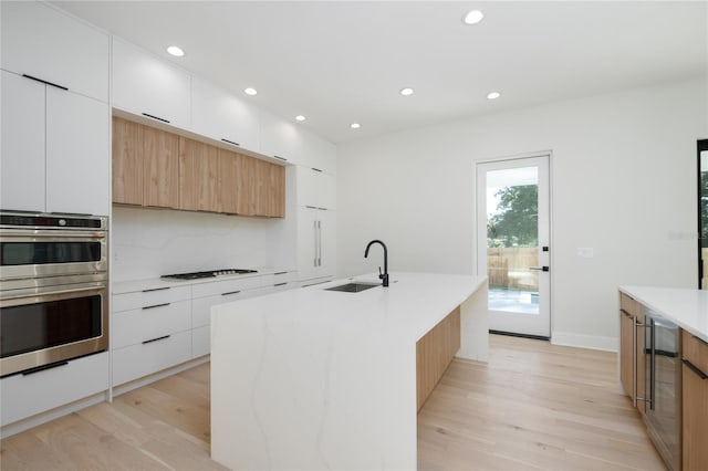 kitchen featuring light countertops, modern cabinets, a sink, and white cabinets