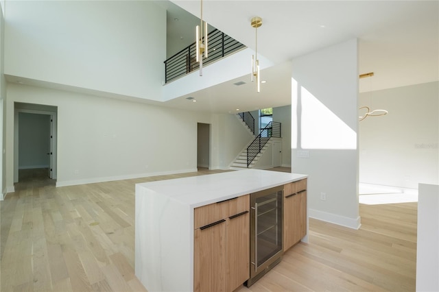 kitchen with wine cooler, light wood-style floors, open floor plan, light countertops, and modern cabinets