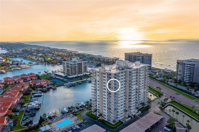 aerial view at dusk featuring a water view