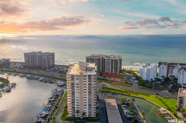 aerial view at dusk featuring a water view