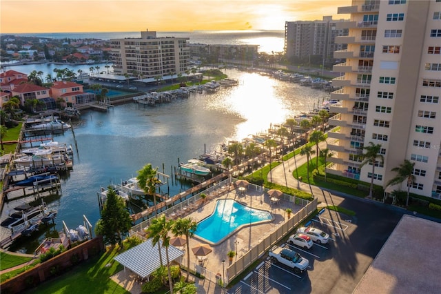 aerial view at dusk featuring a water view