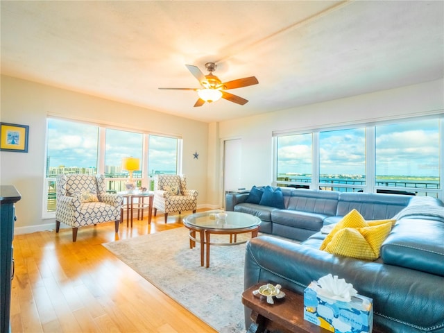 living room featuring a healthy amount of sunlight, ceiling fan, and light hardwood / wood-style flooring