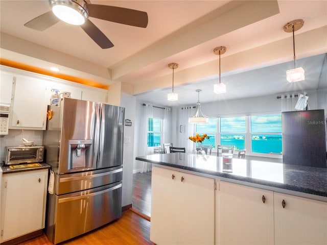 kitchen featuring white cabinetry, backsplash, stainless steel fridge with ice dispenser, light hardwood / wood-style floors, and pendant lighting