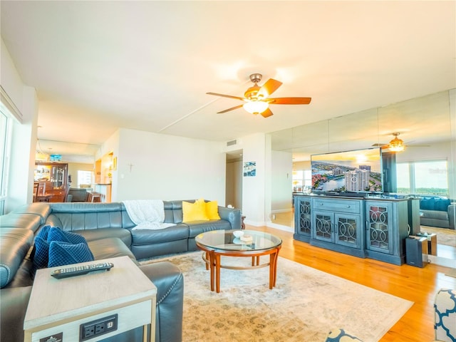 living room with light hardwood / wood-style floors and ceiling fan