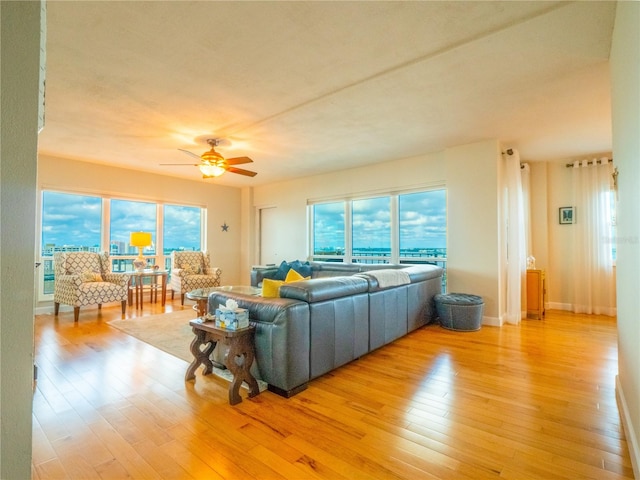 living room featuring light hardwood / wood-style floors, ceiling fan, and a wealth of natural light