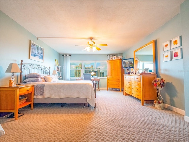 bedroom with light colored carpet, ceiling fan, and multiple windows