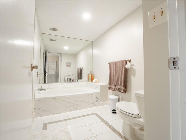 bathroom with toilet, a relaxing tiled bath, and tile flooring