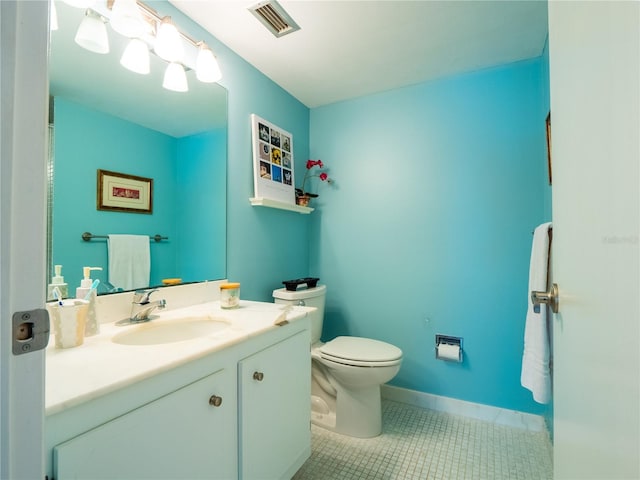 bathroom with toilet, large vanity, and tile flooring