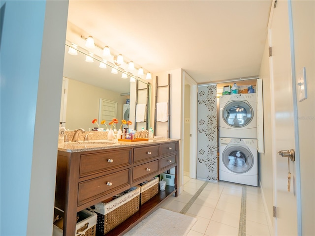 laundry room with light tile floors, stacked washer and clothes dryer, and sink