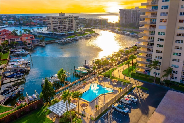 aerial view at dusk featuring a water view