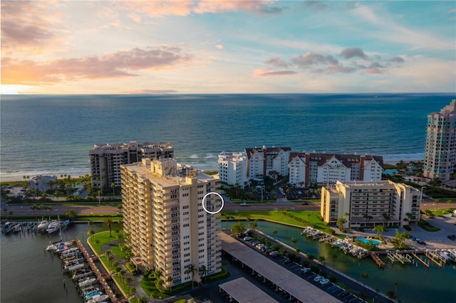 aerial view at dusk featuring a water view