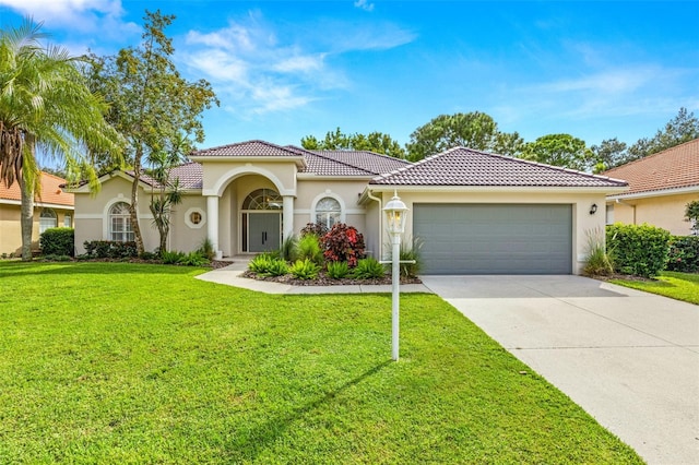 mediterranean / spanish-style house featuring a front yard and a garage