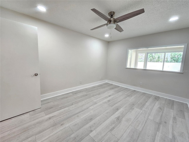 spare room featuring ceiling fan, light hardwood / wood-style floors, and a textured ceiling