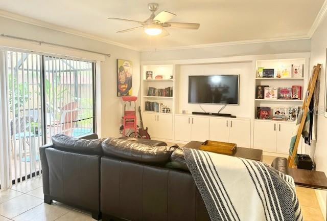 tiled living room featuring built in shelves, a healthy amount of sunlight, ceiling fan, and crown molding