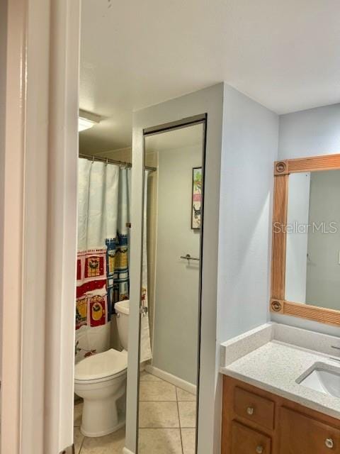 bathroom featuring toilet, tile floors, and vanity