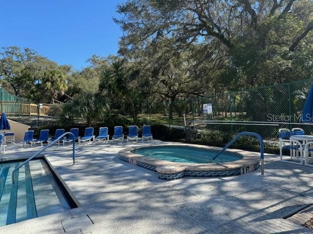 view of pool with a hot tub and a patio