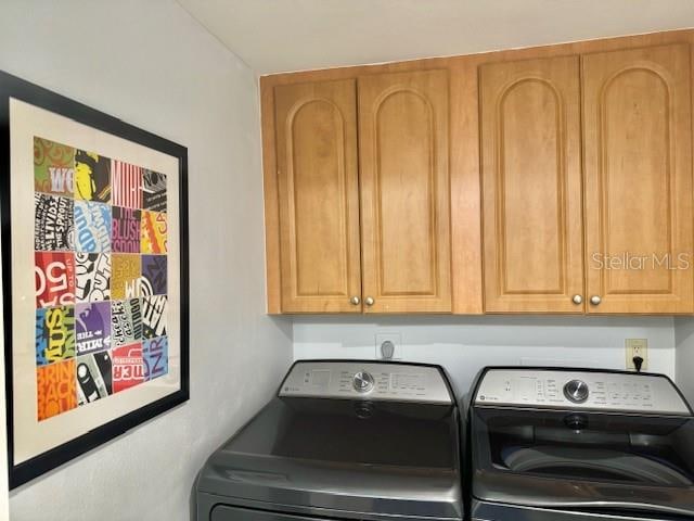 washroom with washer and clothes dryer and cabinets