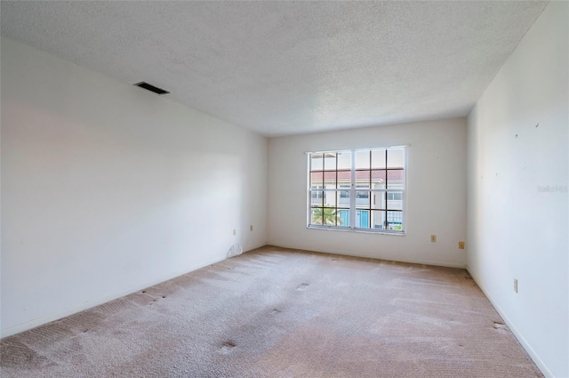 carpeted spare room with a textured ceiling