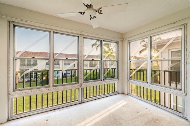 unfurnished sunroom with ceiling fan