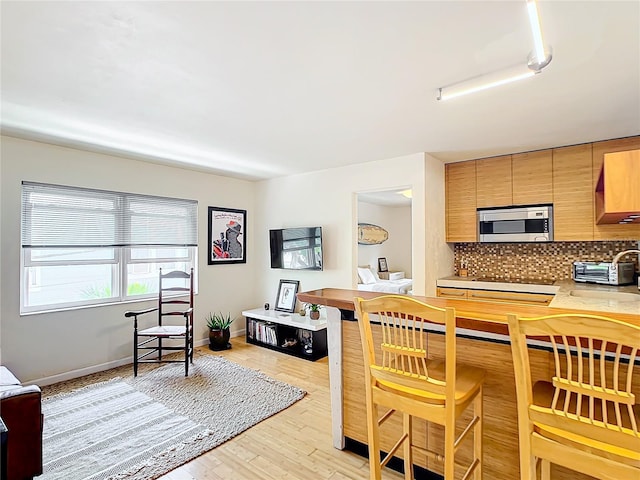 kitchen featuring backsplash, black electric stovetop, and light hardwood / wood-style flooring