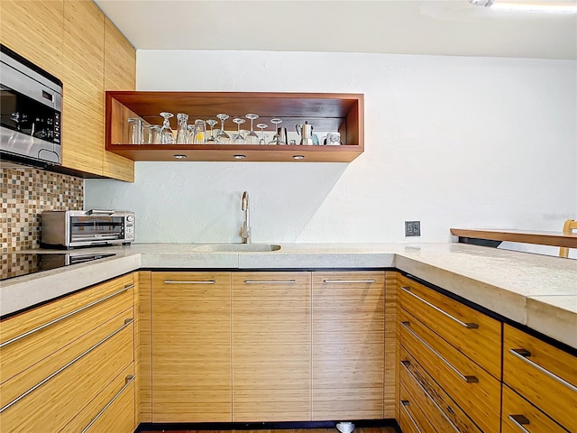 kitchen with backsplash, stainless steel microwave, and sink