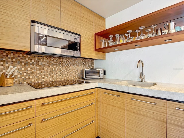 kitchen featuring backsplash, sink, and black electric stovetop