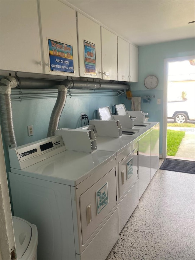 washroom featuring cabinets and washer and clothes dryer