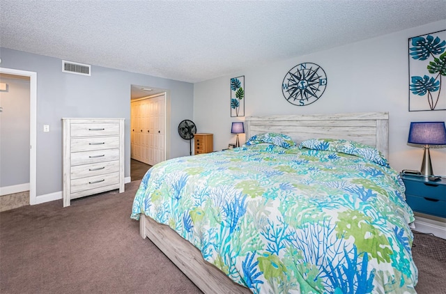 bedroom featuring a closet, dark carpet, and a textured ceiling