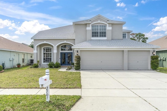 front of property featuring french doors, a front yard, and a garage