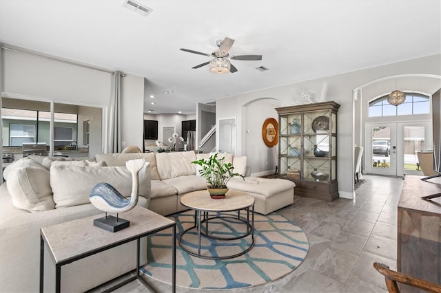 living room with light tile floors, ceiling fan, and french doors