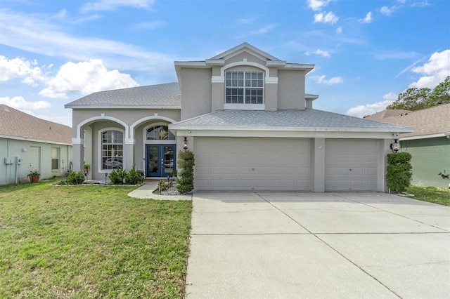 view of property featuring a front yard and a garage