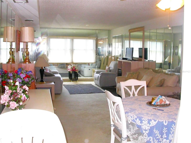 carpeted dining room with a textured ceiling