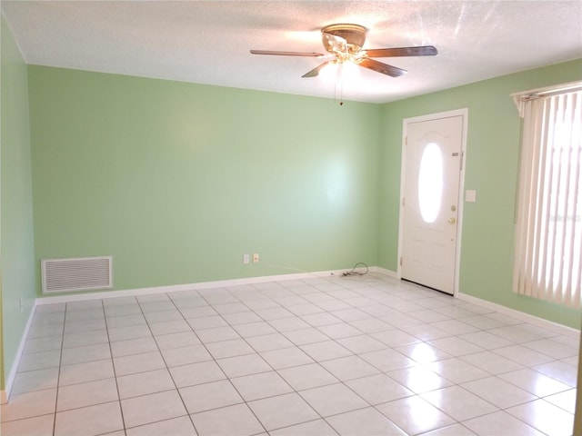 foyer with ceiling fan, light tile patterned floors, plenty of natural light, and a textured ceiling