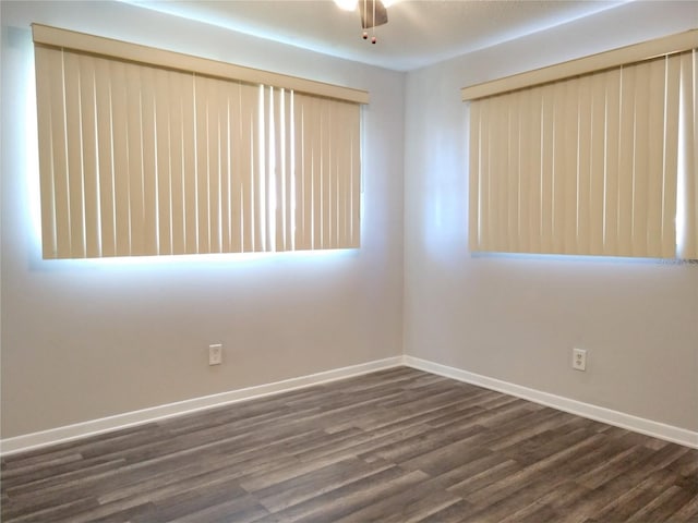 spare room with ceiling fan, dark wood finished floors, and baseboards