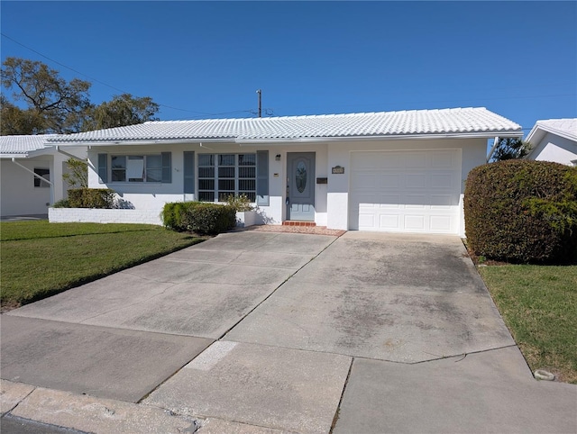 ranch-style home with concrete driveway, a tiled roof, a front lawn, and stucco siding