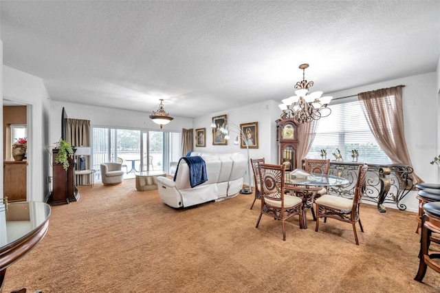 dining space featuring a chandelier, a textured ceiling, and light colored carpet