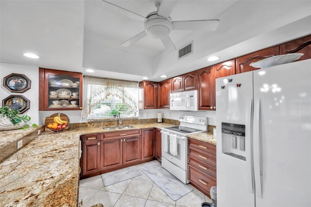 kitchen with white appliances, visible vents, light stone counters, and a sink