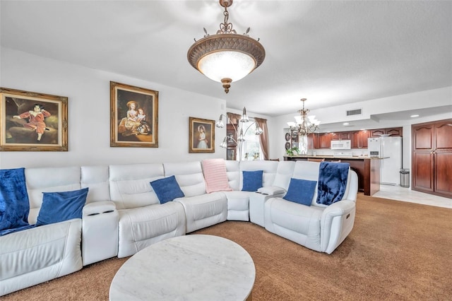 living area with light carpet, visible vents, and a notable chandelier