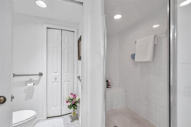 bathroom with a closet, a shower stall, toilet, and recessed lighting